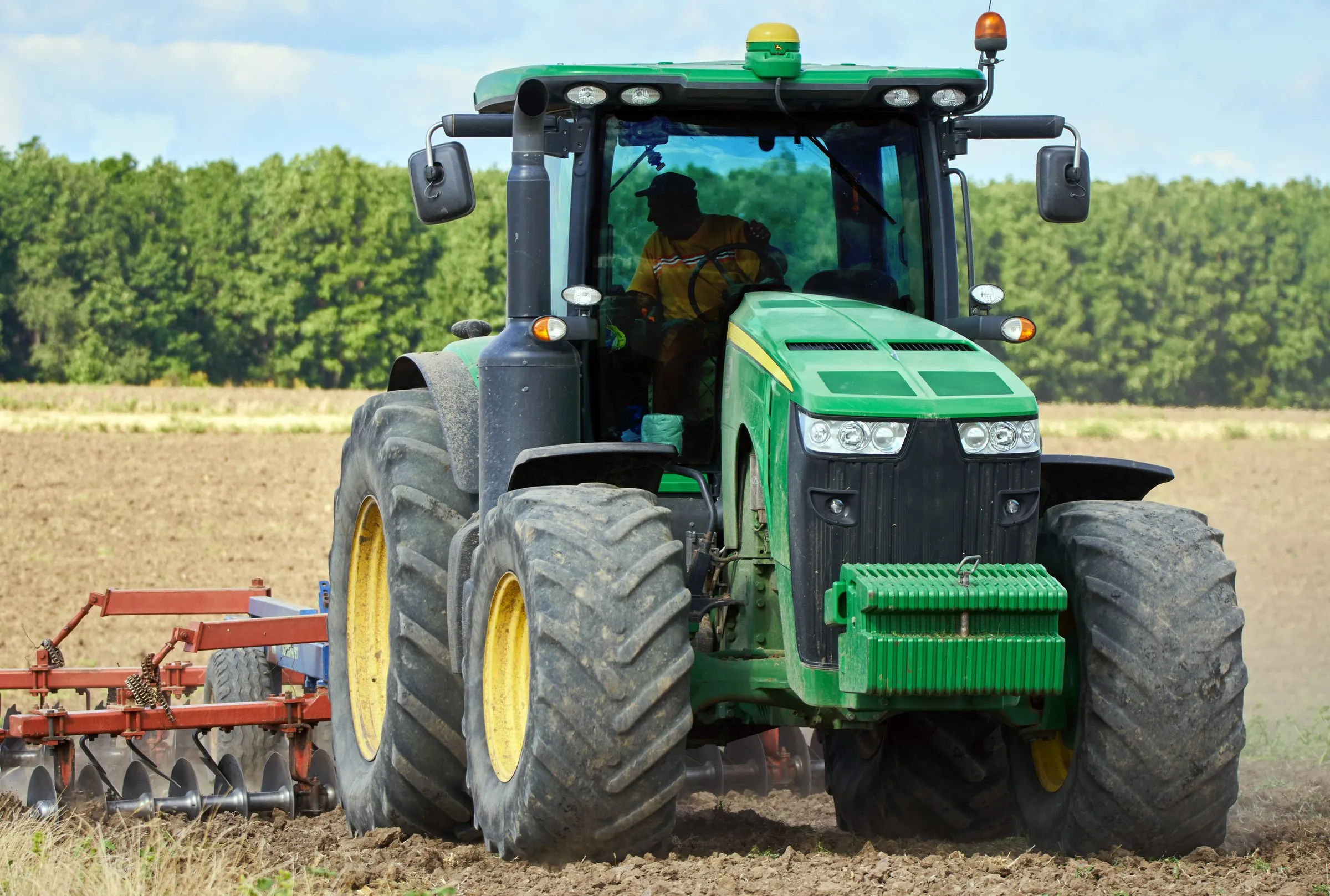 Tractor de frente con implemento sobre tierra preparada